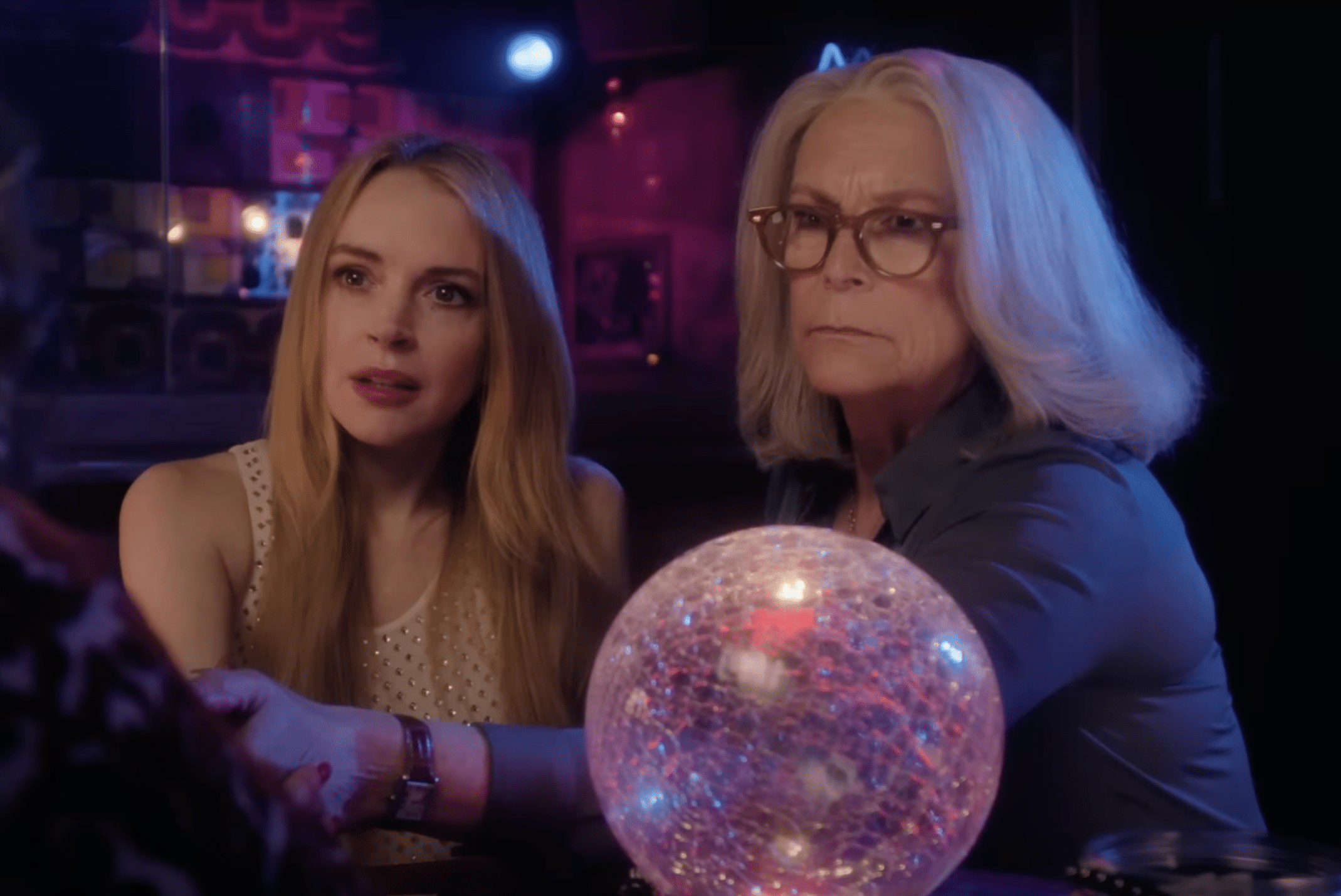 Anna and Tess sitting with a crystal ball, having their fortune told.